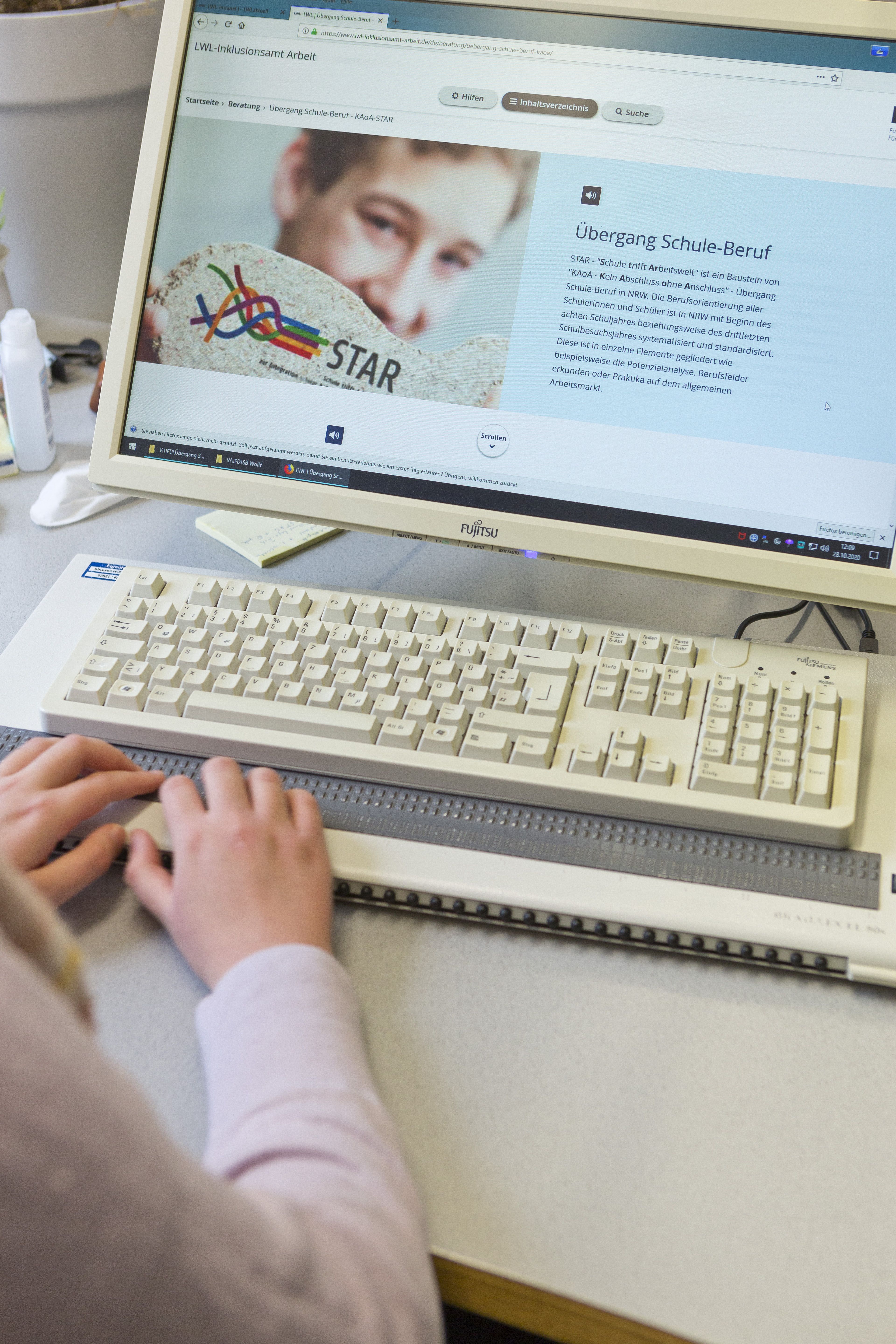 Frau schriebt per Blindenschrifttastatur am PC