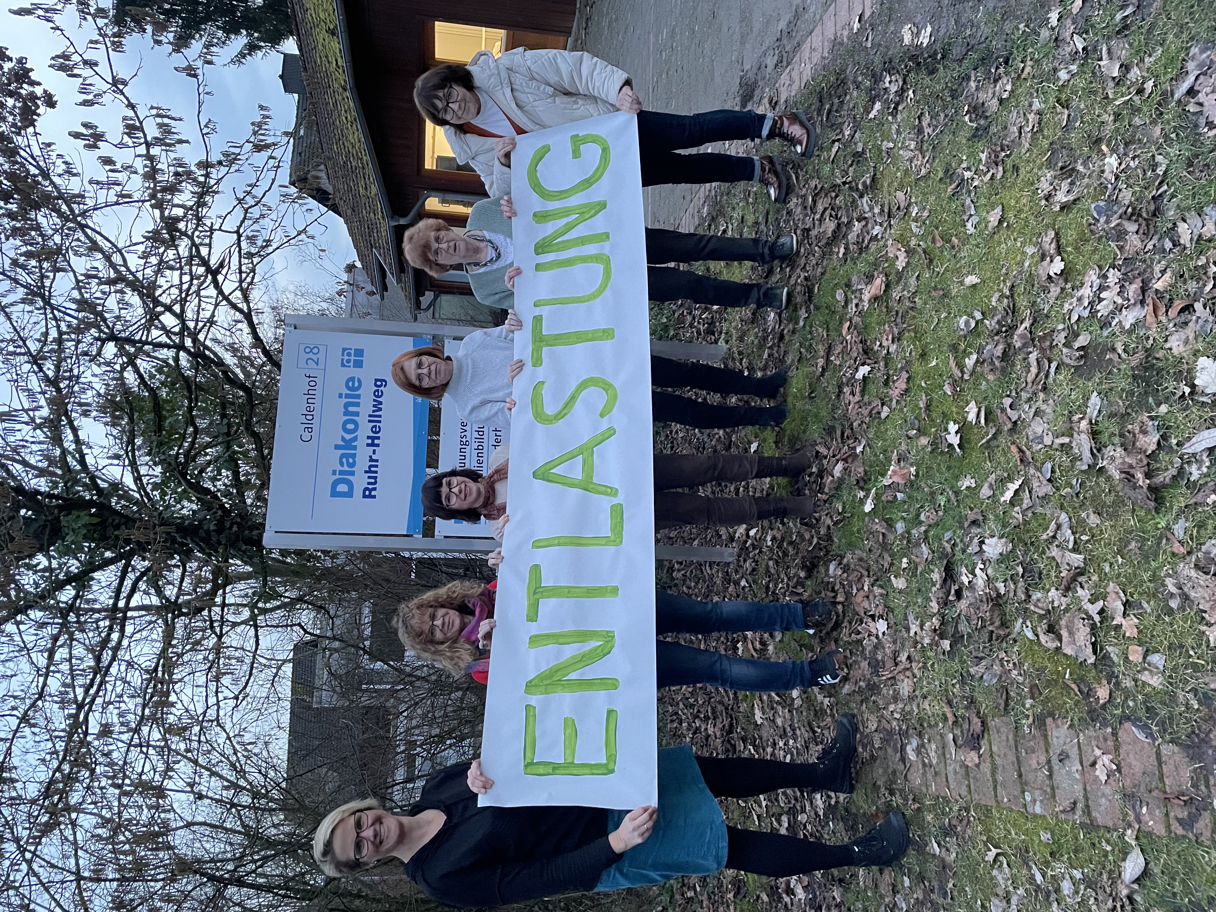 Das Familienpattinnen Team Hamm steht mit einem Banner vorm Caldenhof.