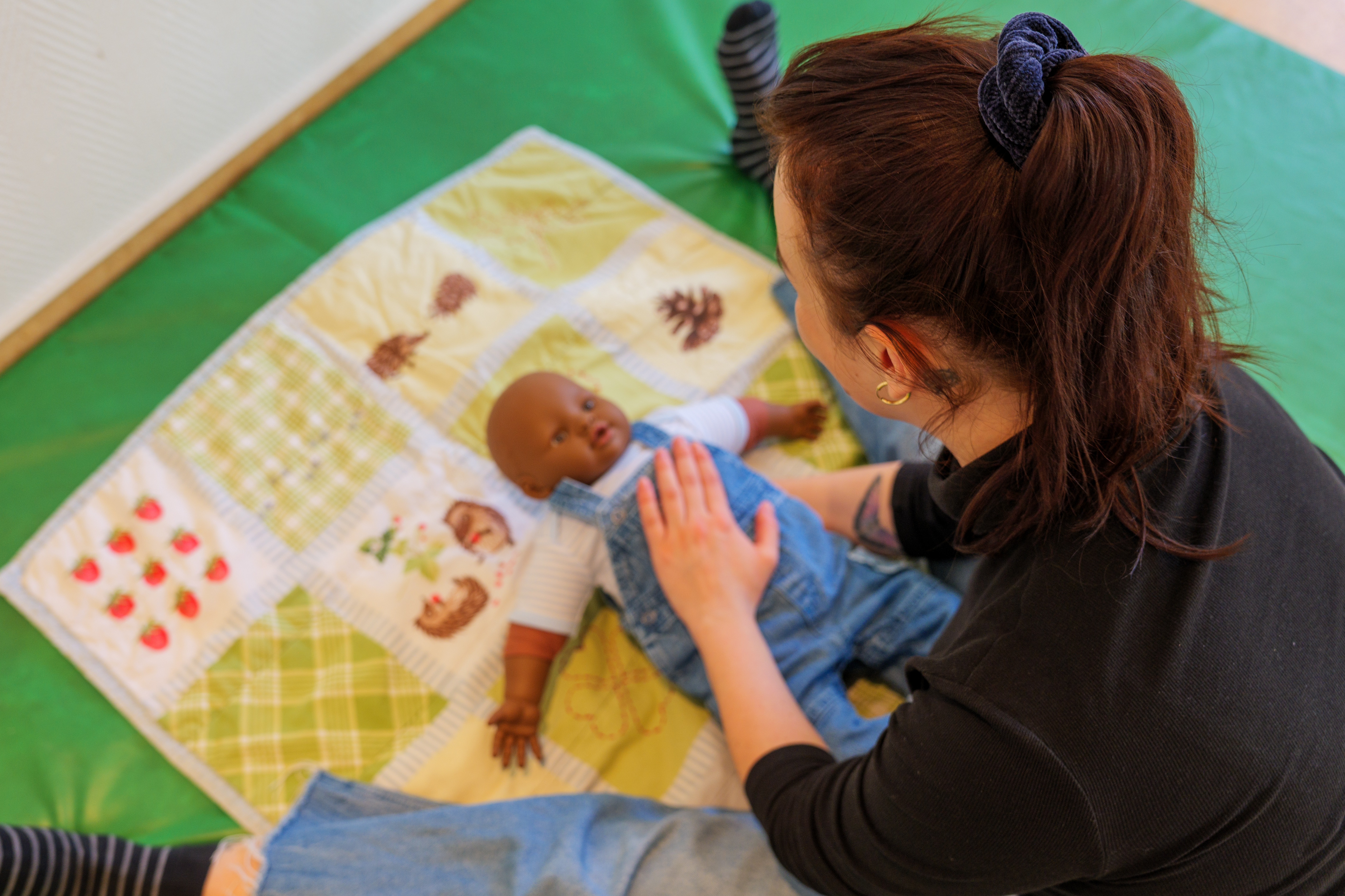 Frau übt an einer Baby Puppe