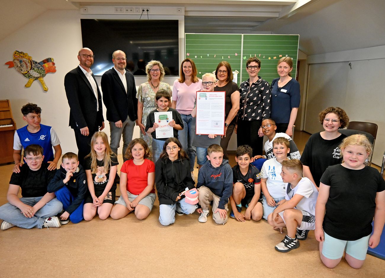 Foto zeigt Mitarbeiter und Schüler mit Auszeichnung "Schule mit Biss"