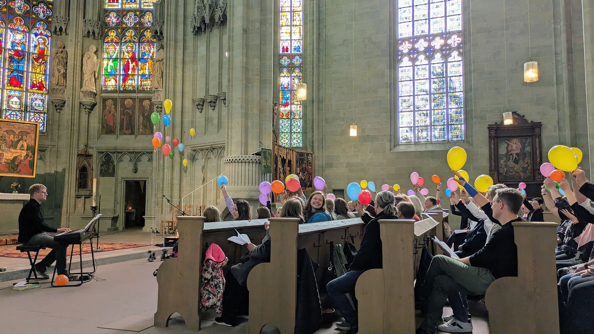 Menschen freuen sich und halten bunte Luftballons in die Luft