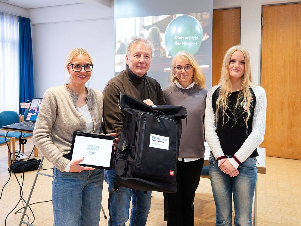 Bild zeigt Pfarrerin Leona Holler, mit Teamerin Antonia Dahhoff, sowie Kathrin Dohle und Udo Sedlaczek von der Diakonie mit dem neuen Konfi-Rucksack