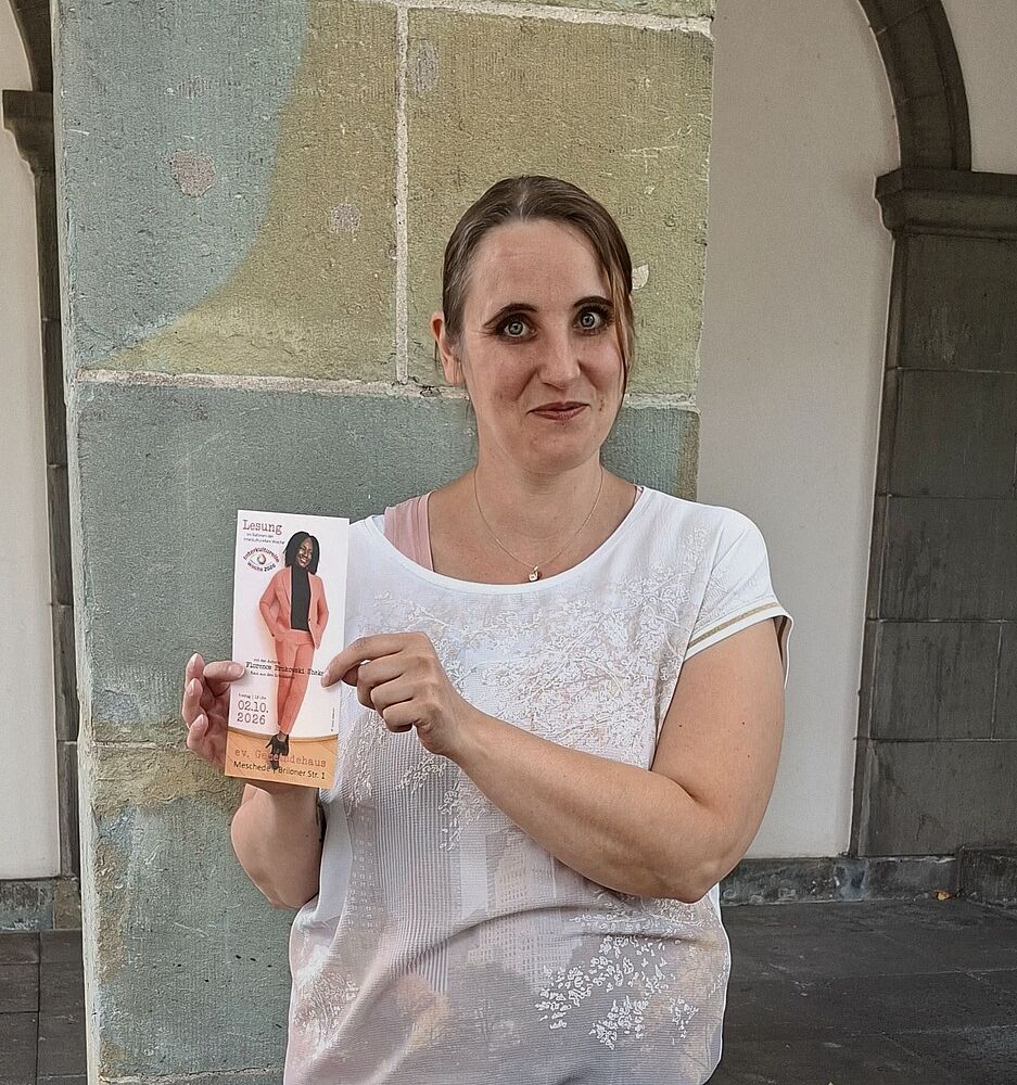 Foto zeigt Mitarbeiterin der Flüchtlingsberatung mit Flyer zur Lesung