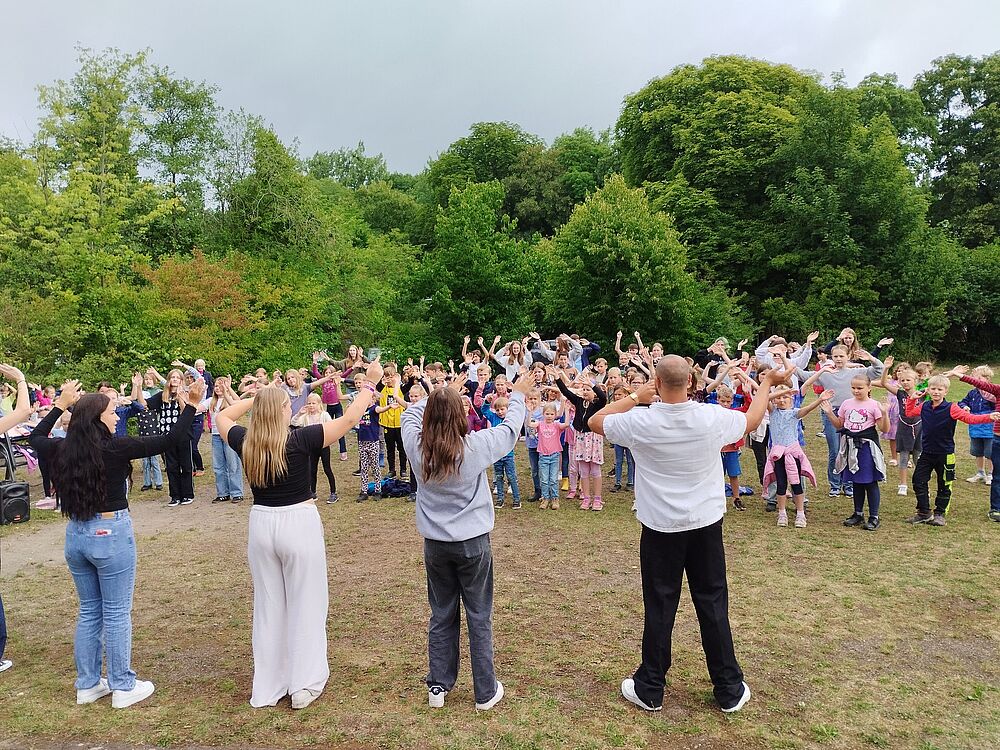 Kinder und Jugendliche tanzen gemeinsam