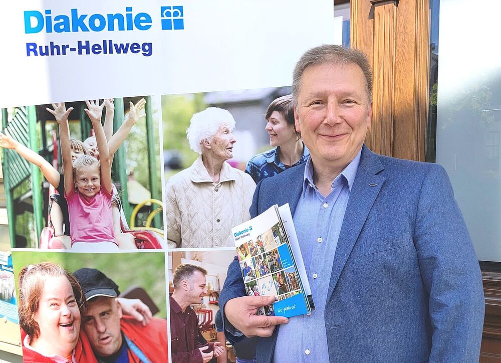 Bild zeigt Fundraiser Udo Sedlaczek mit Broschüre der Diakonie